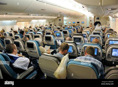 passengers sitting in economy-class cabin seats Singapore Airlines ...