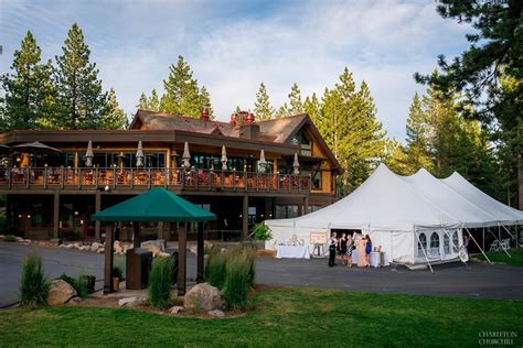 a photo of the Tahoe Donner Lodge with a wedding going on with a large white tent by the golf ...