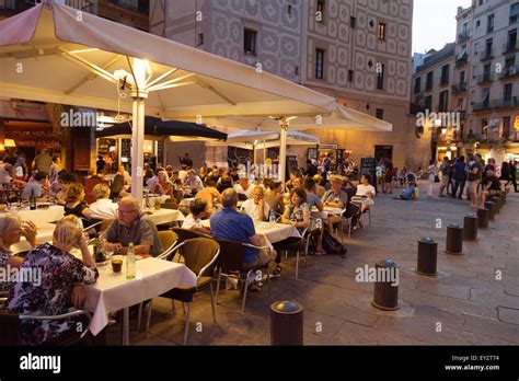 People eating outdoors at night at a restaurant in the Ribera district ...