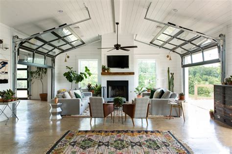 [Room] Living area in a converted barn features polished concrete floors and dual garage doors ...