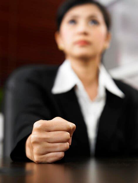 Premium Photo | Mid adult businesswoman clenching fist on office desk