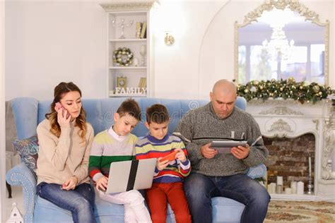 La Famiglia Moderna E Mobile, I Due Figli Ed Il Marito E La Moglie Sono Occupati Immagine Stock ...