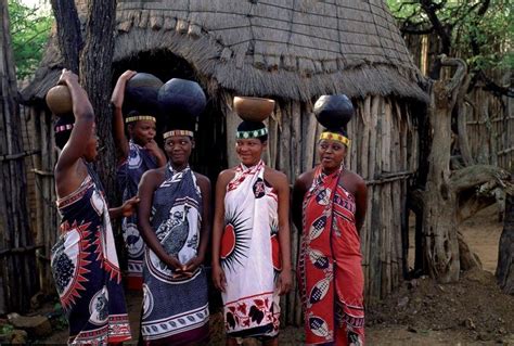 some people are standing in front of a hut