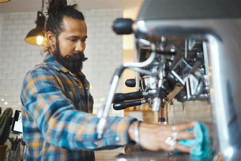 Premium Photo | Man in coffee shop barista cleaning machine for drink ...