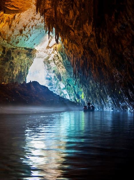 Premium Photo | Tour by boat tourists in a cave with an underground ...