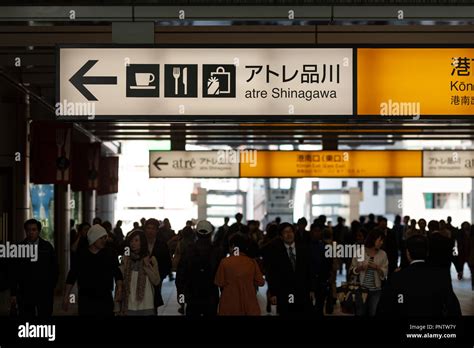 Overhead direction signs above backlit commuters in Tokyo, Japan Stock ...