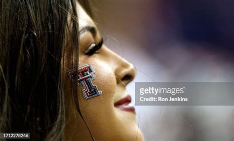 A Texas Tech Red Raiders cheerleader looks on as Texas Tech plays ...