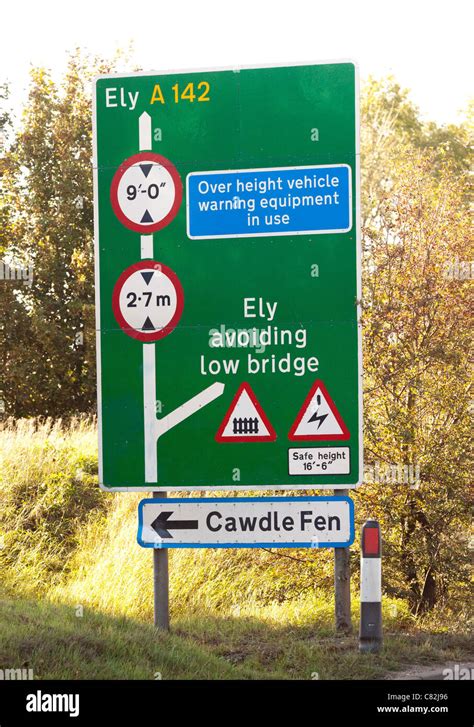 sign warning of height restrictions of low bridge ahead Stock Photo - Alamy