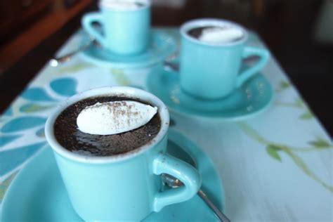 two cups of hot chocolate with marshmallows in them on a blue plate