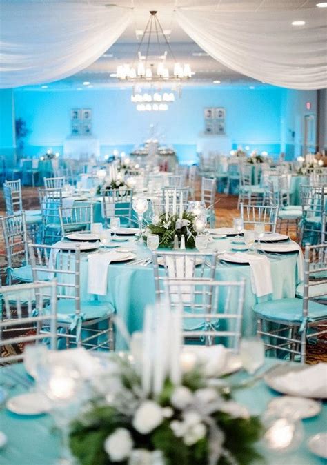 tables and chairs are set up for an event with blue linens, white ...