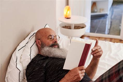 "Mature Man Reading A Book On His Bed" by Stocksy Contributor "Ivan ...