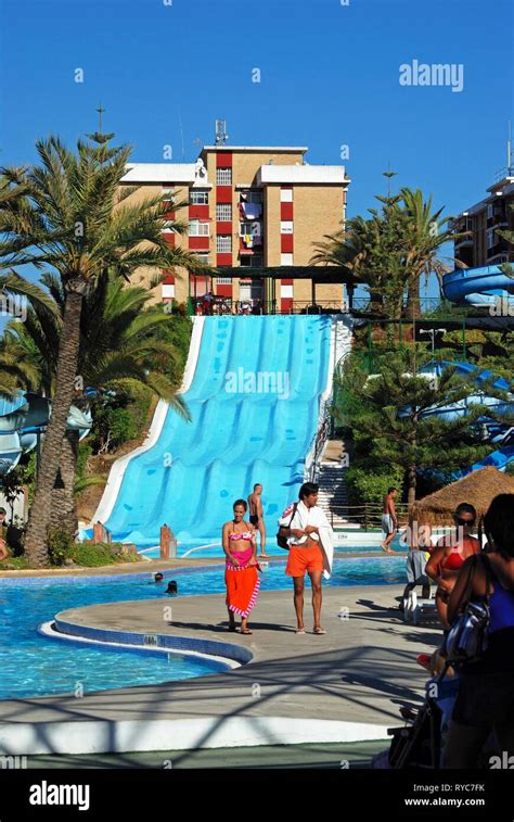 Water slide and pool in the water park with tourists enjoying the ...