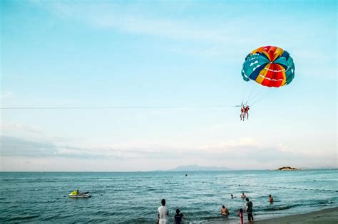 Person Riding Parachute Above Ocean · Free Stock Photo