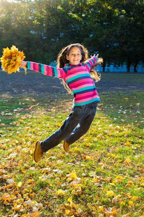 Girl Jumping into Leaf Pile Stock Image - Image of jump, youth: 11620871