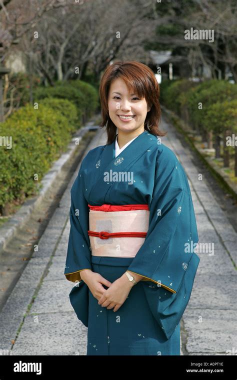 Beautiful Japanese woman wearing traditional kimono poses in Kyoto ...