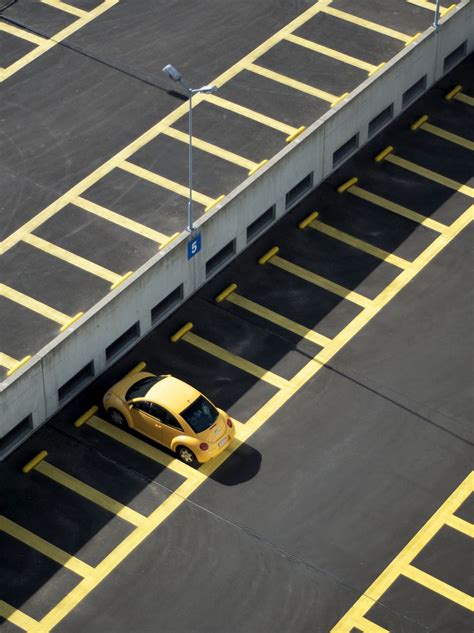 Drone shot of a solitary yellow Volkswagen Beetle in a parking garage ...