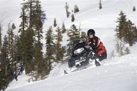 Rider on a snowmobile surrounded by snow-covered mountains Free Stock ...