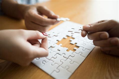 Hands connecting puzzle piece together on wooden table 1924496 Stock ...