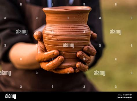 Pottery man hands hold clay pot on his workshop Stock Photo - Alamy