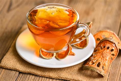 Bael tea on glass with dried bael slices on wooden background, Bael ...