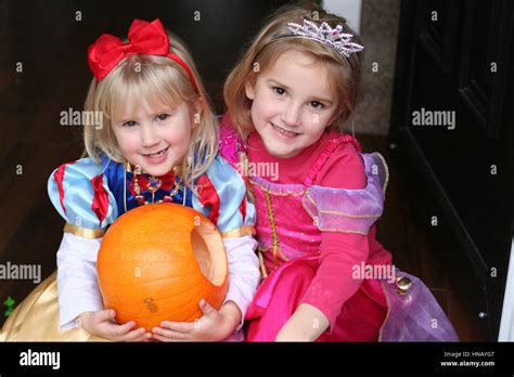 Blonde Children kids holding a heavy carved pumpkin wearing princess ...