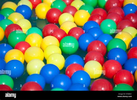 Multi-coloured balls float on water Stock Photo - Alamy