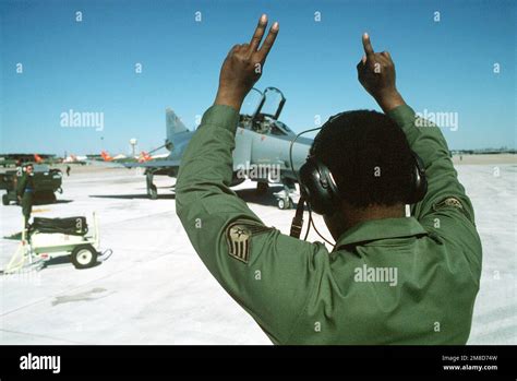 A ground crew member signals to the pilot of a 37th Tactical Fighter ...