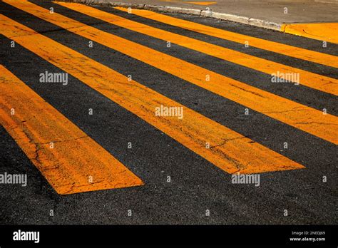 Yellow painted crosswalk road line markings Stock Photo - Alamy