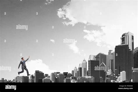 Young businessman running over city buildings and skyscrapers Stock ...