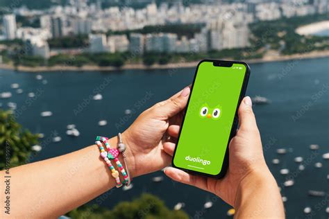 Girl holding smartphone with Duolingo language-learning app on screen ...