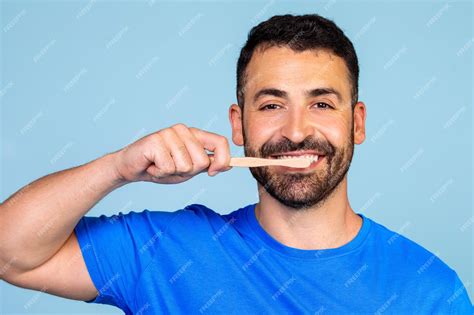 Un hombre guapo cepillándose los dientes con un cepillo de dientes de ...