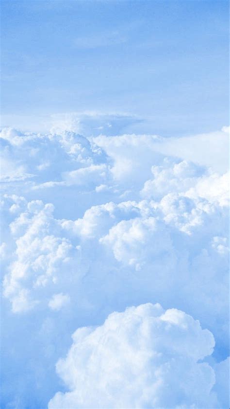 an airplane is flying high in the sky above some fluffy white clouds ...