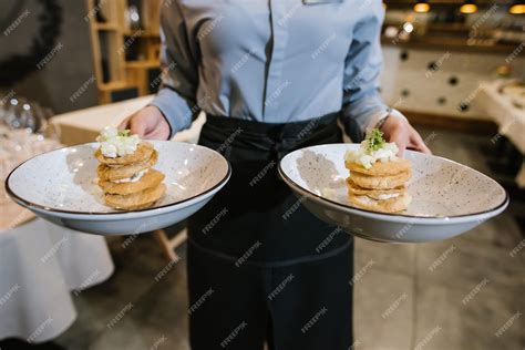 Un serveur apporte le plat aux clients au restaurant | Photo Premium