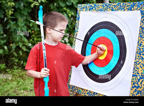 Little archer with bow and arrow outdoors Stock Photo - Alamy