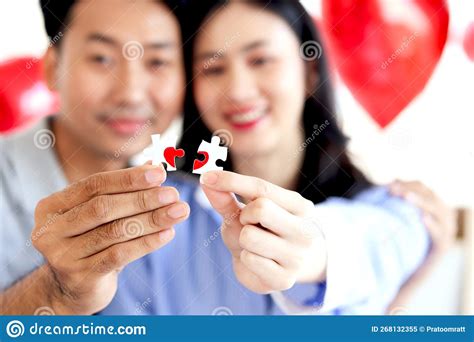 Happy Asian Couple Holding Two Pieces Of Puzzle Forming Red Heart And ...