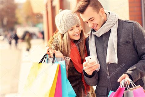 Happy couple shopping in the city with smartphone — Stock Photo ...