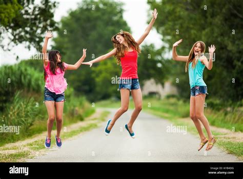 Three happy girls jumping Stock Photo - Alamy