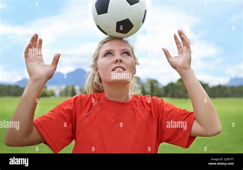 Its all about balance. Shot of a young female soccer player balancing a ...