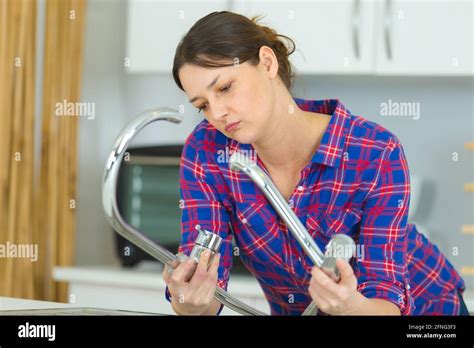 woman is trying to repair a water tap Stock Photo - Alamy