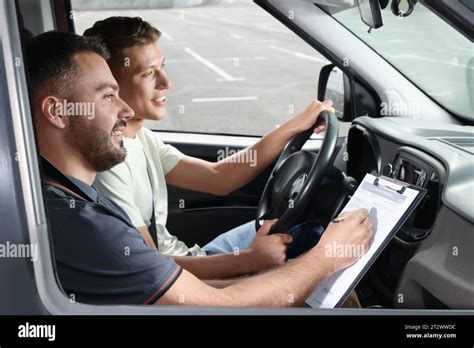Driving school. Student passing driving test with examiner in car at ...
