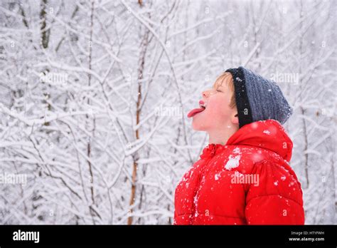 Boy catching snowflakes in his mouth Stock Photo - Alamy