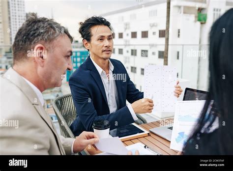 Finance manager talking to colleagues at meeting Stock Photo - Alamy