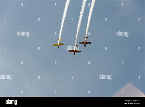 Airplane stunts on the blue sky leaving contrail Stock Photo - Alamy