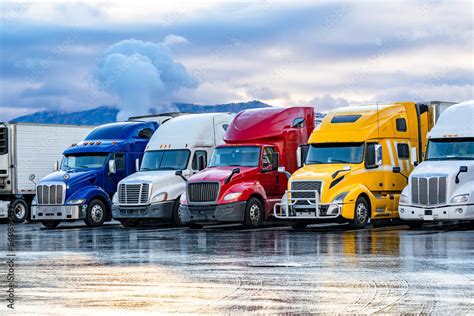 Bright colorful big rigs semi trucks with semi trailers standing in the ...