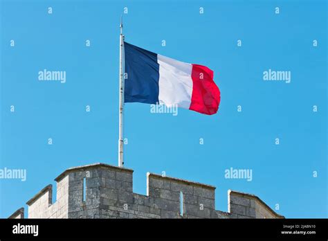 National Flag of France waving in the wind on top of historical castle ...
