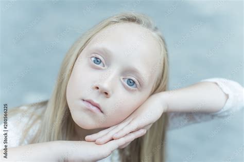 a gentle young albino girl with smooth and even hair, pale white skin ...