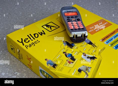 Un téléphone sur le haut d'un annuaire des Pages Jaunes Photo Stock - Alamy