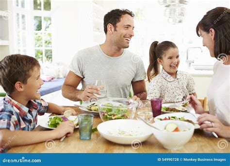 Family Eating Meal Around Kitchen Table Together Stock Photo - Image ...
