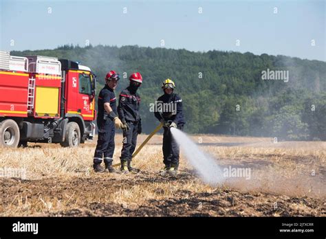 Firefighters extinguishing a stubble fire in a field already harvested ...
