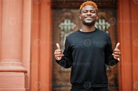 l'homme aux cheveux rouge africain porte une tenue noire posant à l ...